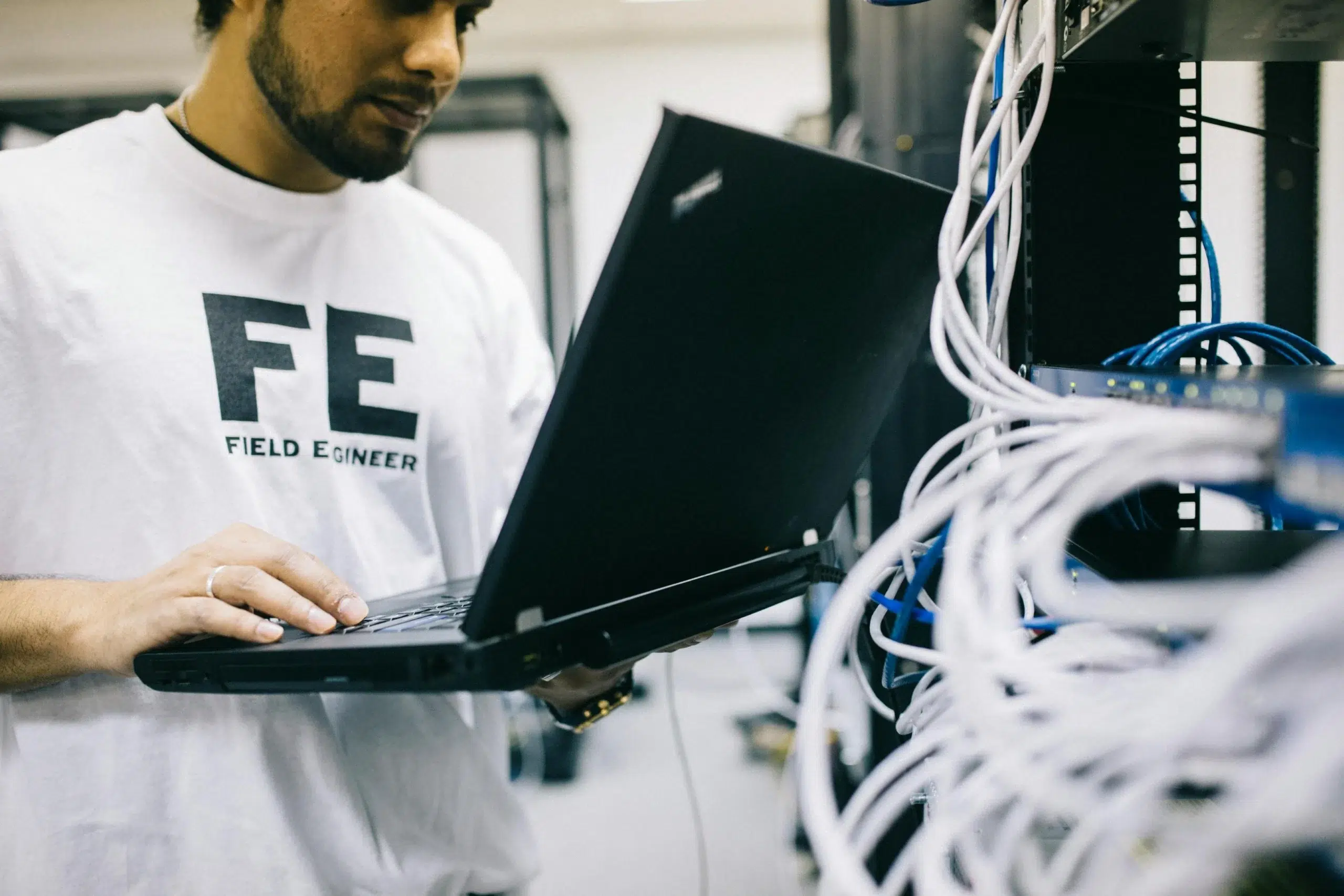 A maintenance manager using a laptop in a hangar to coordinate preventive maintenance schedules for large-scale maritime equipment and multi-site industrial assets.